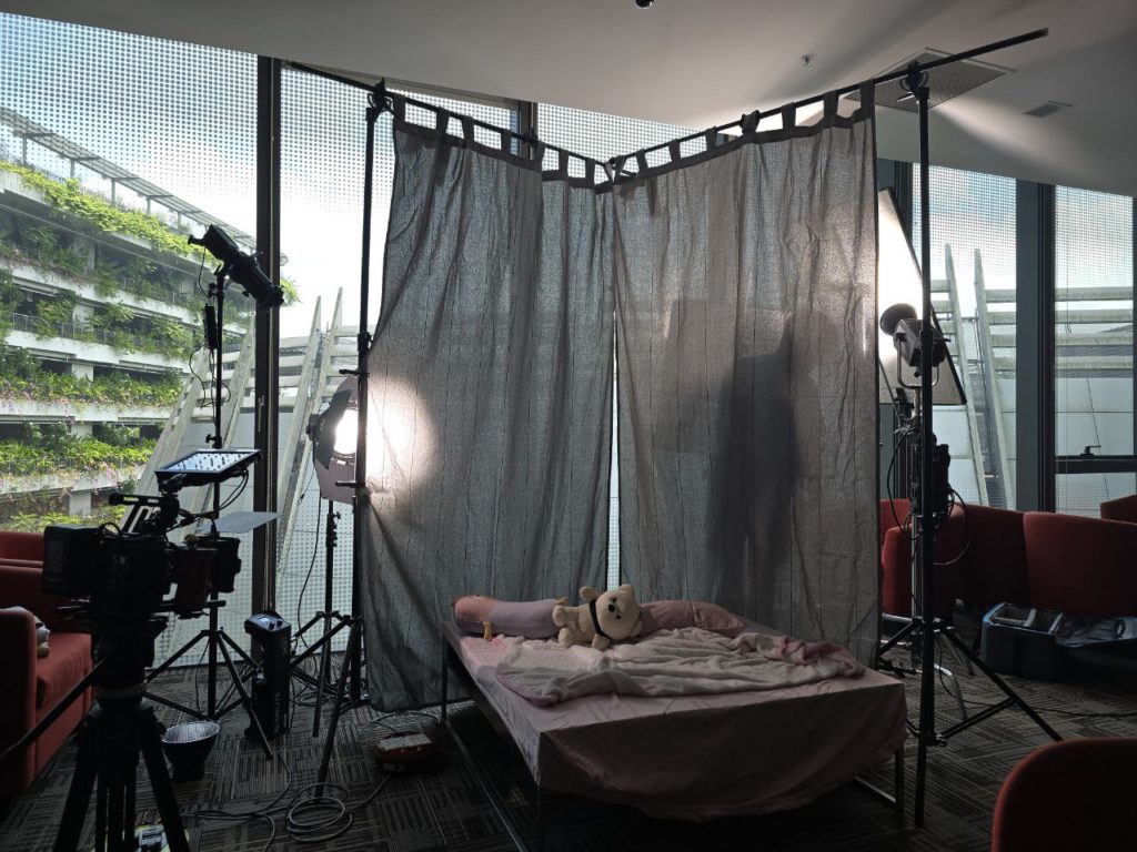 BTS Behind-the-scenes view of a makeshift bedroom set during video production