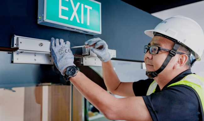 Engineer in blue-collar workwear with hard hat and measuring instrument