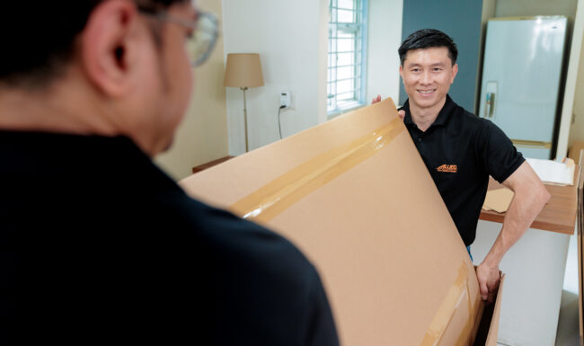 Two people from Sirva Asia holding shipping box.