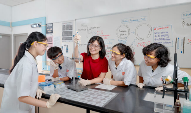 Teacher and students in school uniforms in classroom.