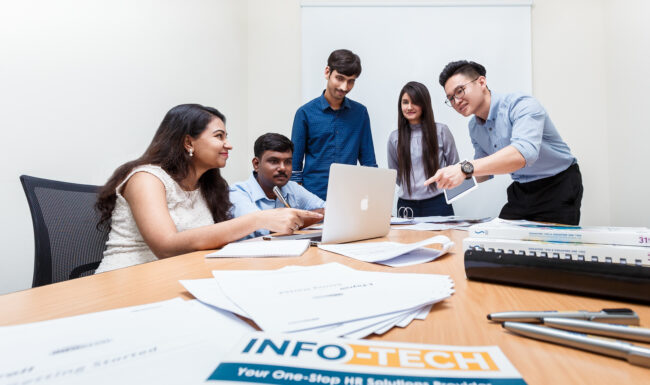 Five white-collar workers collaborating in a meeting.